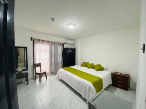 1 dormitorio con 1 cama grande con almohadas verdes en Carpao Lodging Galapagos, en Puerto Ayora