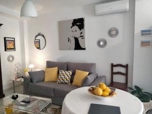 een woonkamer met een bank en een tafel met een fruitschaal bij Casa Mila in Fuengirola
