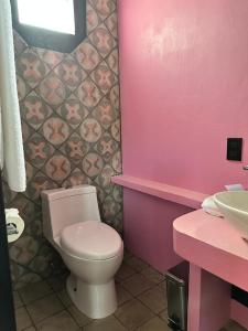Baño de color rosa con aseo y lavamanos en Casa Rosa Hotel & Spa en San Cristóbal de Las Casas