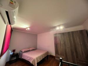 a small bedroom with a bed and a dresser at Apartamentos Cerro Blanco in Santiago