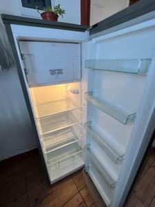 an empty refrigerator with its door open in a kitchen at Apartamentos Cerro Blanco in Santiago