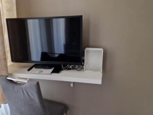 a television sitting on a shelf on a wall at Aparthotel LAAERBERG in Vienna