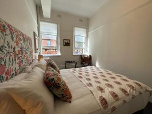 a bedroom with a large bed and two windows at The Resch House in Sydney