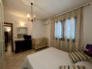 - une chambre avec un lit blanc et un lit bébé dans l'établissement Lupa Di Mare Casa Vacanze, à Otrante
