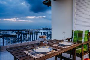 a wooden table on a balcony with a view of the ocean at Penthouse of diamond in Athens