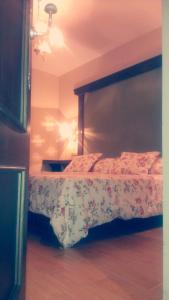 1 dormitorio con 1 cama con colcha de flores en El Huésped del Sevillano AR, en Lagartera