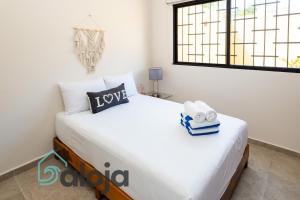 a bedroom with a large white bed with a window at Ideal estudios cálidos y acogedores in Cancún