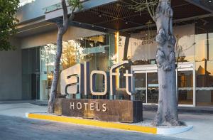 Aloft Playa del Carmen في بلايا ديل كارمن: علامة الفندق أمام المبنى