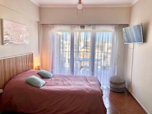 1 dormitorio con cama y ventana grande en El Reino MdQ en Mar del Plata