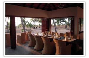 een eetkamer met een tafel en stoelen met uitzicht bij Kanan Beach Resort in Nīleshwar