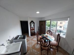 uma cozinha com uma mesa e cadeiras e um lavatório em Los balcones ll em Medellín