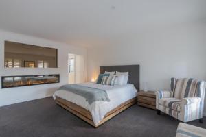 ein Schlafzimmer mit einem großen Bett und einem Stuhl in der Unterkunft Yarra Valley Escape in Healesville