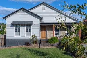 uma casa branca com uma porta de madeira e um quintal em Yarra Valley Escape em Healesville