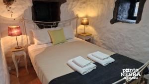 een slaapkamer met een bed met twee handdoeken erop bij Casa da Serreta 17 in Serreta