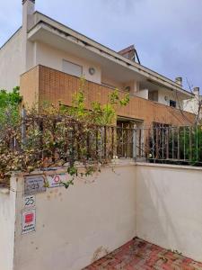 ein Gebäude mit einem Zaun mit Pflanzen darauf in der Unterkunft La Sosta House Anzio in Anzio