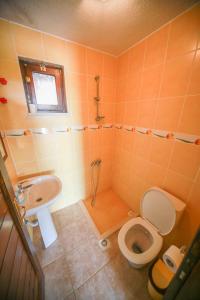 a bathroom with a toilet and a sink at Troia Pension in Akçapınar