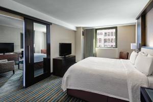 a hotel room with a bed and a television at Courtyard New York Manhattan/Times Square in New York