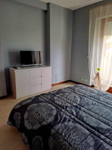 ein Schlafzimmer mit einem großen Bett und einem TV in der Unterkunft La Sosta House Anzio in Anzio