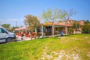 a house with a table and chairs in a yard at Troia Pension in Akçapınar