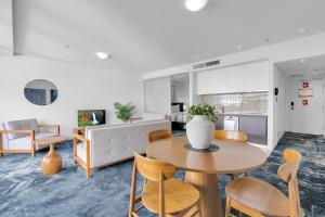 a kitchen and living room with a table and chairs at City Living at Harbour Lights in Cairns