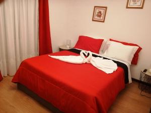 una camera da letto con un letto rosso e asciugamani di Governo's House a Melo