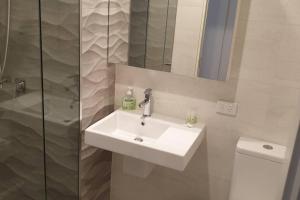 une salle de bain avec un lavabo blanc et une douche dans l'établissement 1011 Arena, à Newcastle