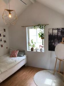 um quarto com uma cama e uma janela com vasos de plantas em Villa Kattrumpan em Kalmar