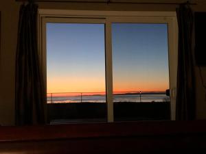 a window with a view of the sunset at Cliffside Cottage in Oak Harbor