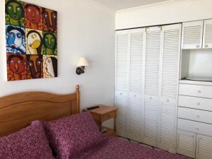 ein Schlafzimmer mit einem Bett, einer Kommode und einem Schrank in der Unterkunft Departamento Playa Paraiso in Concón