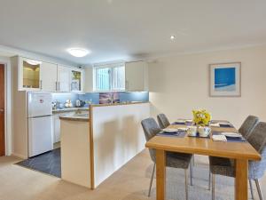 a kitchen and dining room with a table and chairs at Polgew Apartment in Marazion