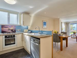 a kitchen with a sink and a table in it at Polgew Apartment in Marazion