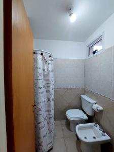 a bathroom with a toilet and a shower curtain at Depto Centro de Carlos Paz in Villa Carlos Paz