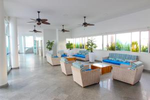 uma sala de estar com sofás, mesas e janelas em Apartamentos Palmetto - Frente al Mar em Cartagena de Indias