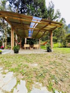 a wooden pergola with a picnic table and swings at Casa completa Bosque Ibagué in Ibagué