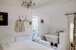 a white bedroom with a sink and a bed and a tub at Jacks Garden Cottage at Poets Lodge in Daylesford +19 photos