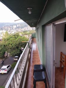 a balcony with chairs and a view of a street at Los balcones l in Medellín
