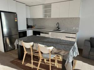 a kitchen with a marble table and four chairs at 1BR City Apt-Parking&View& Homey in Canberra
