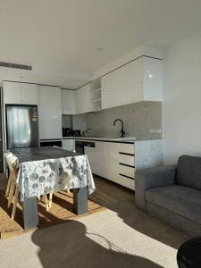 a kitchen with a table and a couch in a room at 1BR City Apt-Parking&View& Homey in Canberra
