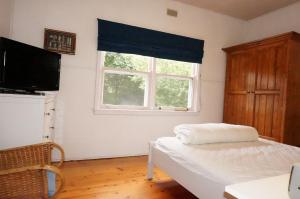 a bedroom with a bed and a television and a window at Dinghys Rest in Queenscliff
