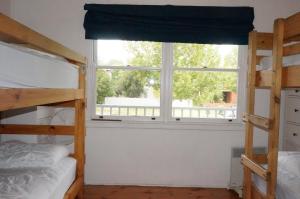 a bedroom with two bunk beds and a window at Dinghys Rest in Queenscliff