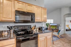 a kitchen with a stove and a microwave at Chic Poolside Oasis - Karaoke - BBQ - Games in Phoenix