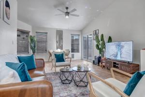 a living room with a couch and a tv at Chic Poolside Oasis - Karaoke - BBQ - Games in Phoenix