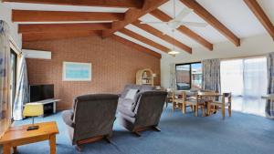 a living room with a table and a dining room at Unit 5 of 11 Beach Street Merimbula in Merimbula
