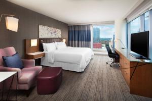 um quarto de hotel com uma cama e uma televisão de ecrã plano em The Westin Austin Downtown em Austin