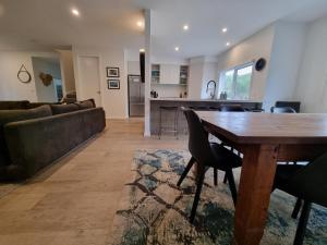 a living room with a wooden table and a couch at Sand Dunes in Point Lonsdale