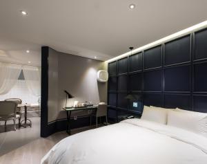 a bedroom with a large bed and a desk at Le Stendal Hotel in Daejeon