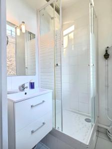 a white bathroom with a shower and a sink at Cosy Studio Père-lachaise-Pelleport in Paris