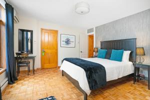 sypialnia z łóżkiem z niebieskimi poduszkami i biurkiem w obiekcie Accueil Chez Francois w Montrealu