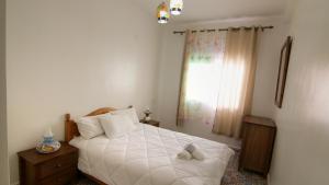 a bedroom with a white bed and a window at zina surf house in Oualidia +7 photos