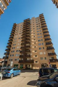 un grand bâtiment avec des voitures garées devant lui dans l'établissement HAFSA apartments Sarajevo City view, à Sarajevo